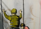 20211116-IMG 2772  Banksy - Fouille en règle (la fille et le soldat)  - Bethléem - Palestine - 2007 - The Word of Banksy -  Paris 9eme - France - le 16/11/2021 : PARIS, STREET ART, STREET ART-BANKSY